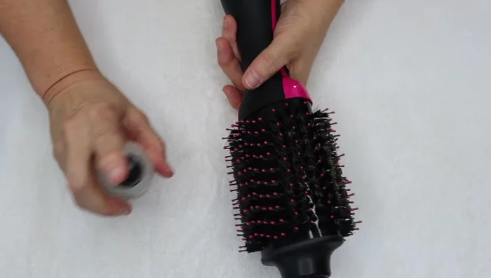 Spray the shampoo mixture onto the bristles, keeping the dryer sideways to avoid getting it into the motor.