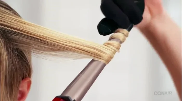 Twist your hair strand before wrapping it around the barrel for defined curls.