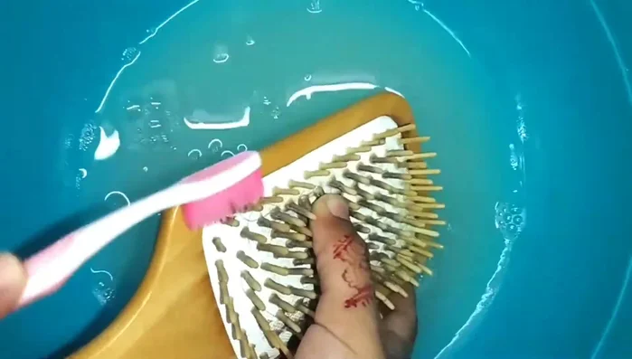 Scrub gently: Use a rough toothbrush or a soft cloth to gently scrub the brush bristles, removing softened dirt.