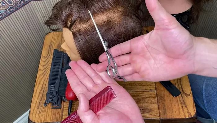 Continue cutting, using the comb to section and control the hair.
