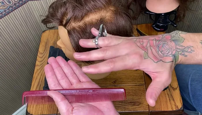 Continue cutting, using the comb to section and control the hair.