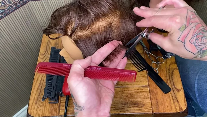 Hold the scissors perpendicular to your hand, with the blade resting on your finger.