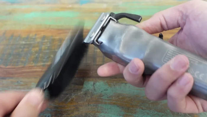 Submerge clippers in clipper side spray to remove built-up hair and gunk (repeat as necessary).