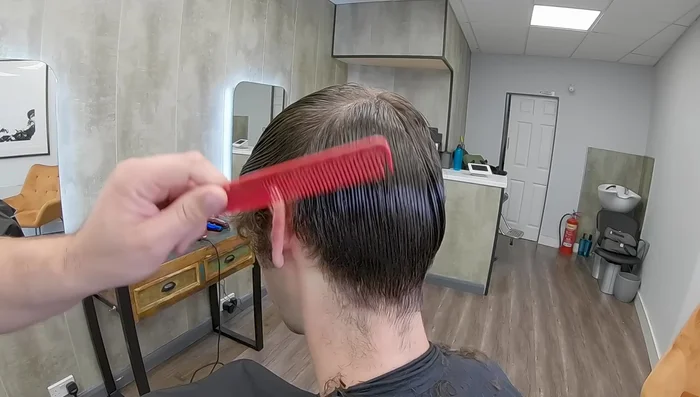Pull the hair towards the ear and cut downwards to create a clean hairline that won't stick out.
