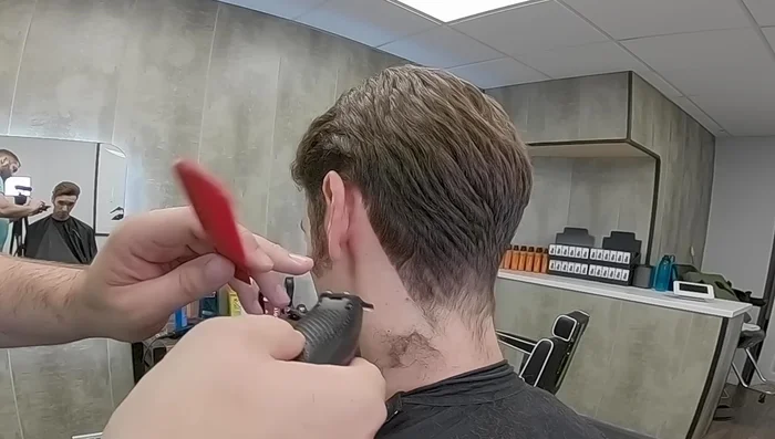 Use the clipper-over-comb technique to carefully remove weight around the ears and sides, avoiding over-tapering.