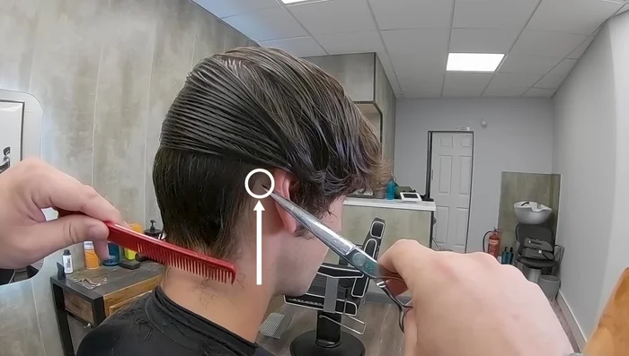 At the back of the ear, place the point of the scissor behind the hairline and slide it in to catch all hair from the hairline.