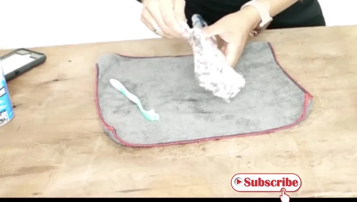 Unwrap the foil. Use a toothbrush to gently scrub away the loosened residue. 