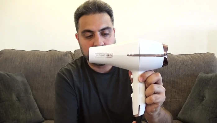 Man holding Conair Infinitipro hair dryer