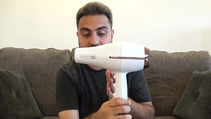 Man holding Conair Infinitipro hair dryer