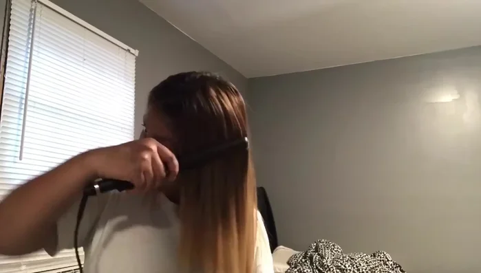 Woman straightening hair with Rusk flat iron
