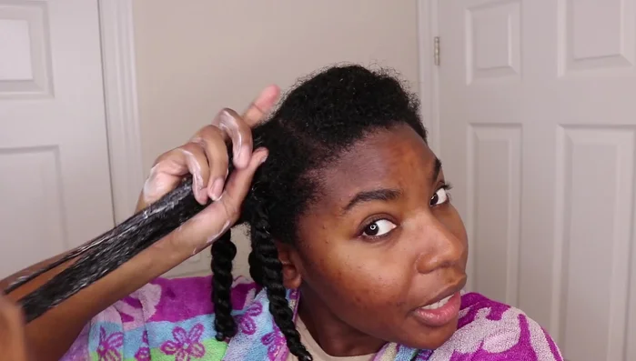 Woman applying hair mask, rich texture.