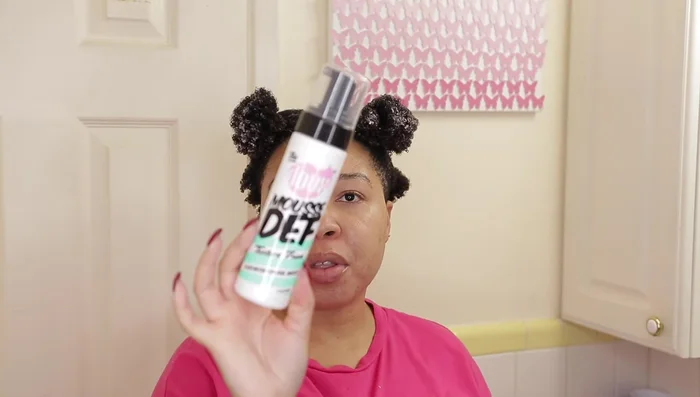 Woman holding Mousse Def styling mousse