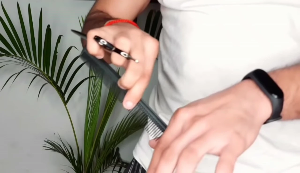 Hands holding comb and scissors