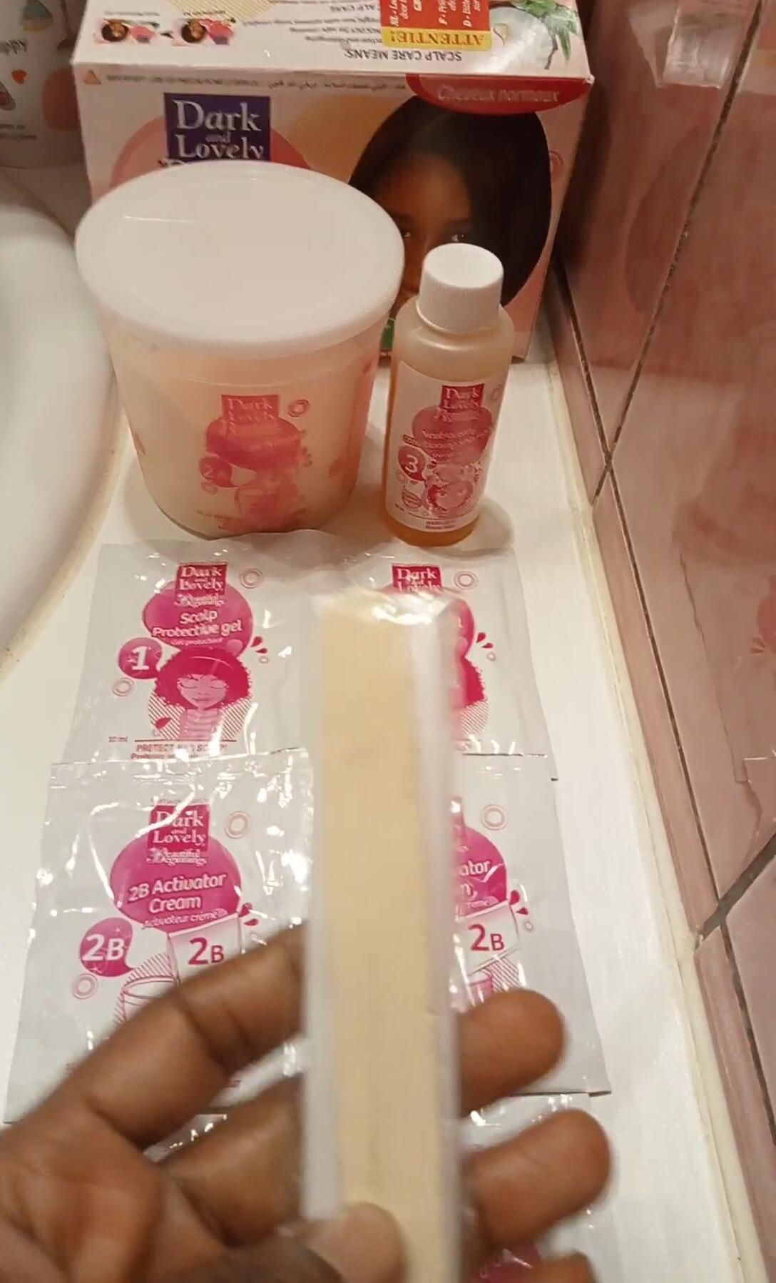 Mixing the activator with the relaxer using the provided stick.