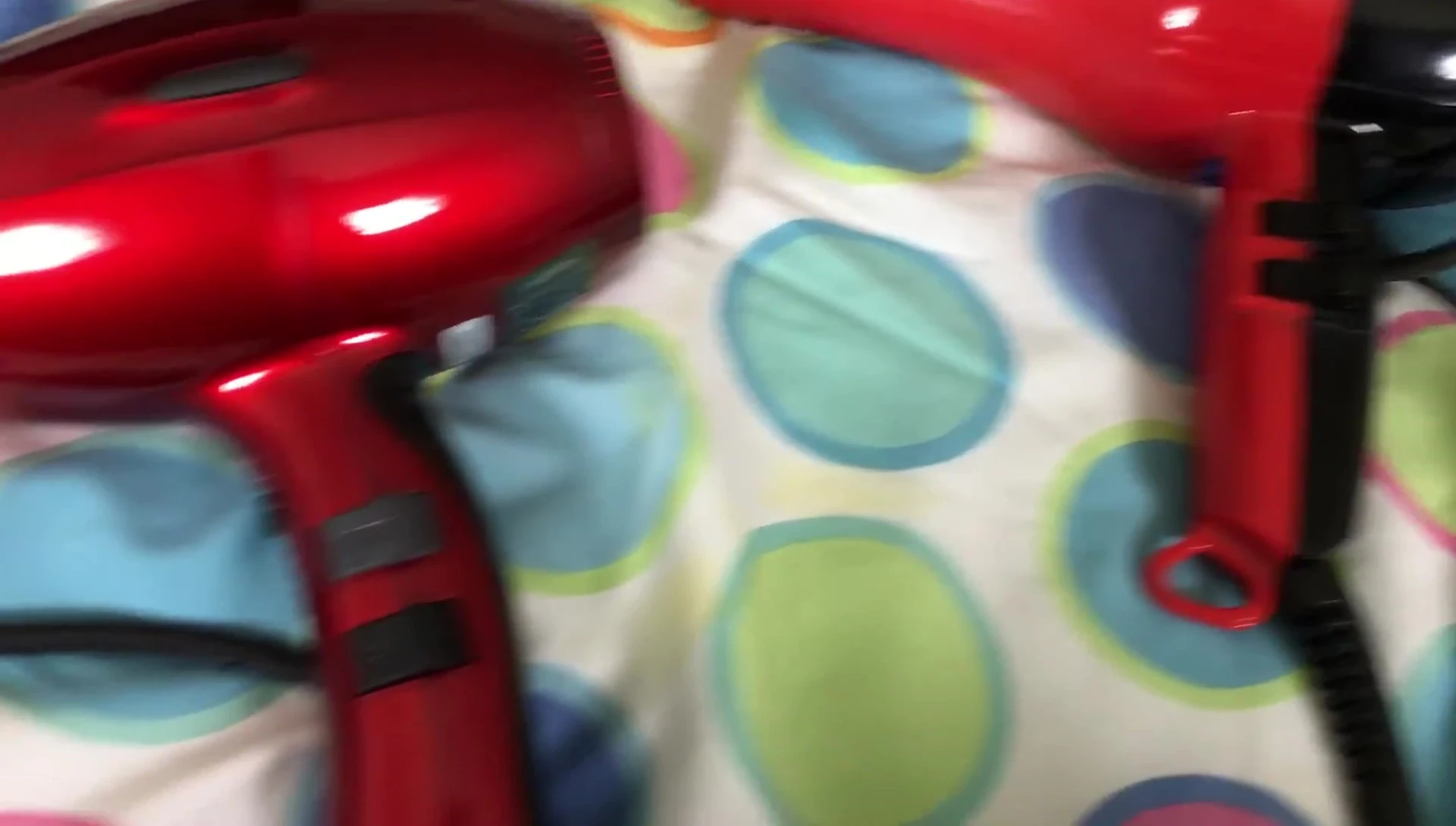 Comparison shot of the controls on both hair dryers, highlighting the differences in size and button placement.