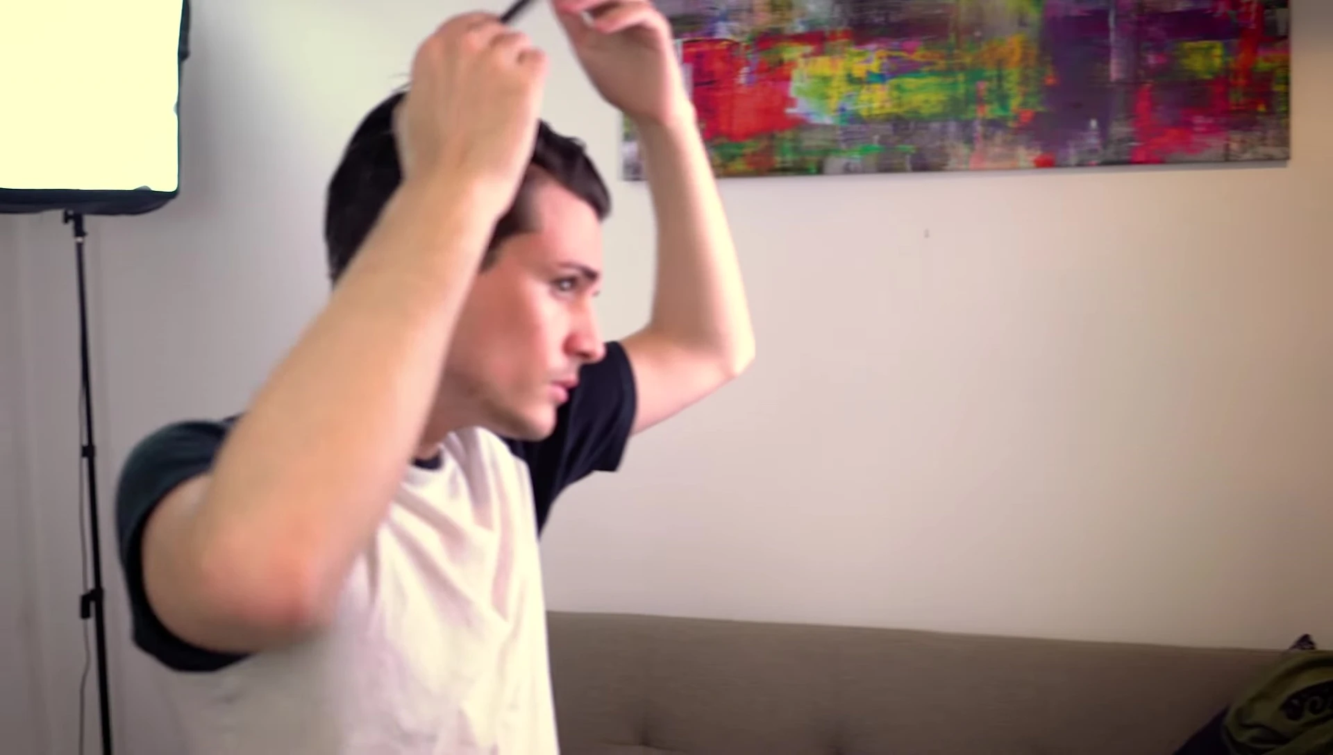 Man demonstrating the use of a comb for a precise hairstyle.