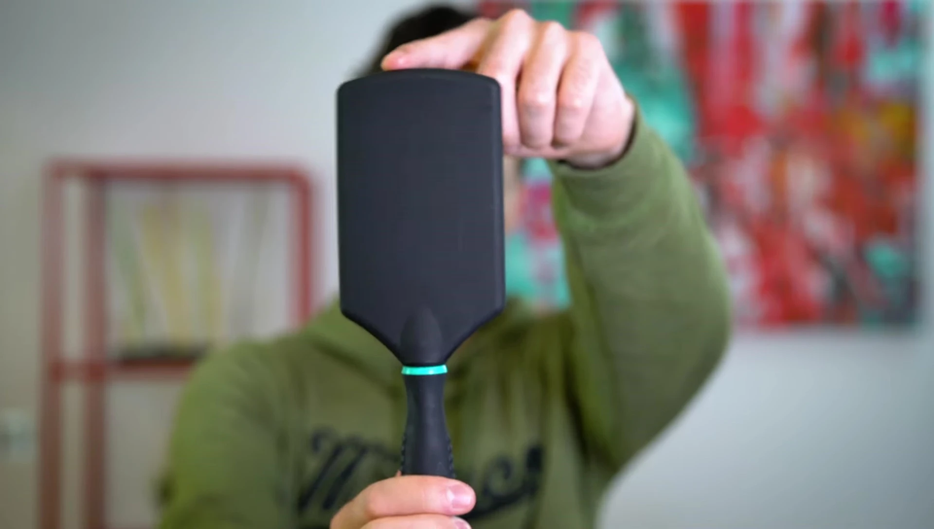 Close-up of a paddle brush being held.