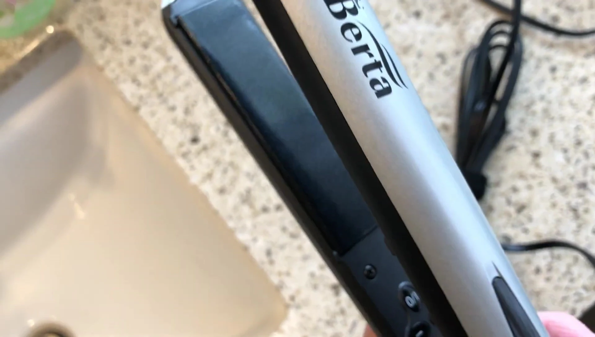 Demonstration of the flat iron gliding through hair.