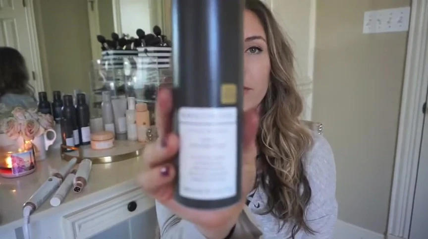 The speaker showing the dry shampoo bottle.