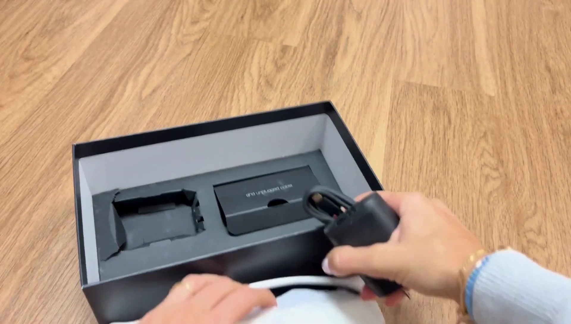 The reviewer displaying the charger and travel pouch together, highlighting the size difference.