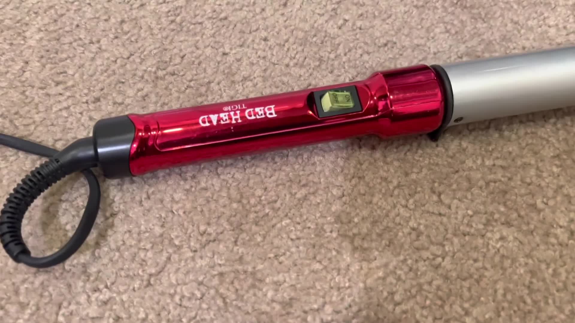Close-up of the Bed Head Curlipops Curling Wand in the reviewer's hand.