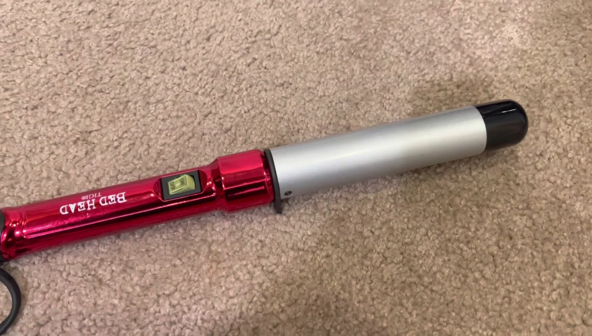 The reviewer demonstrating the curling wand on her hair.