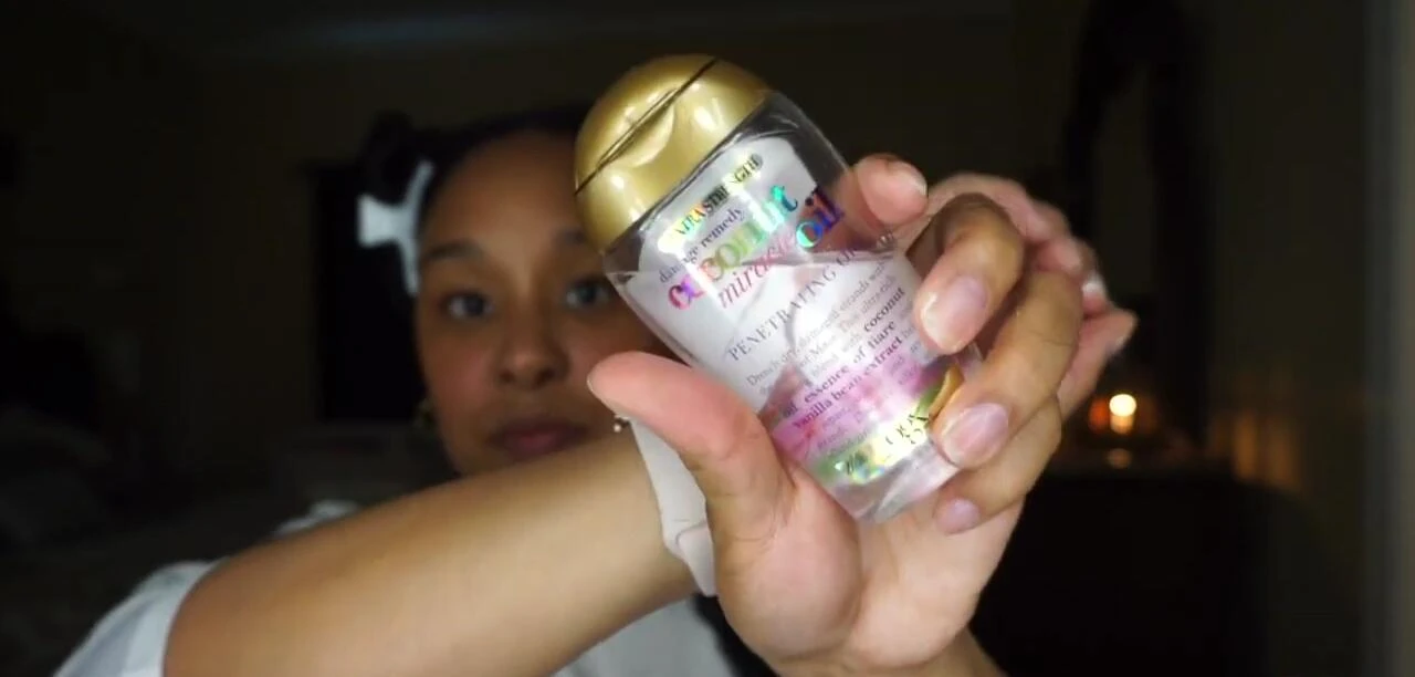 Applying OGX Coconut Miracle Oil.