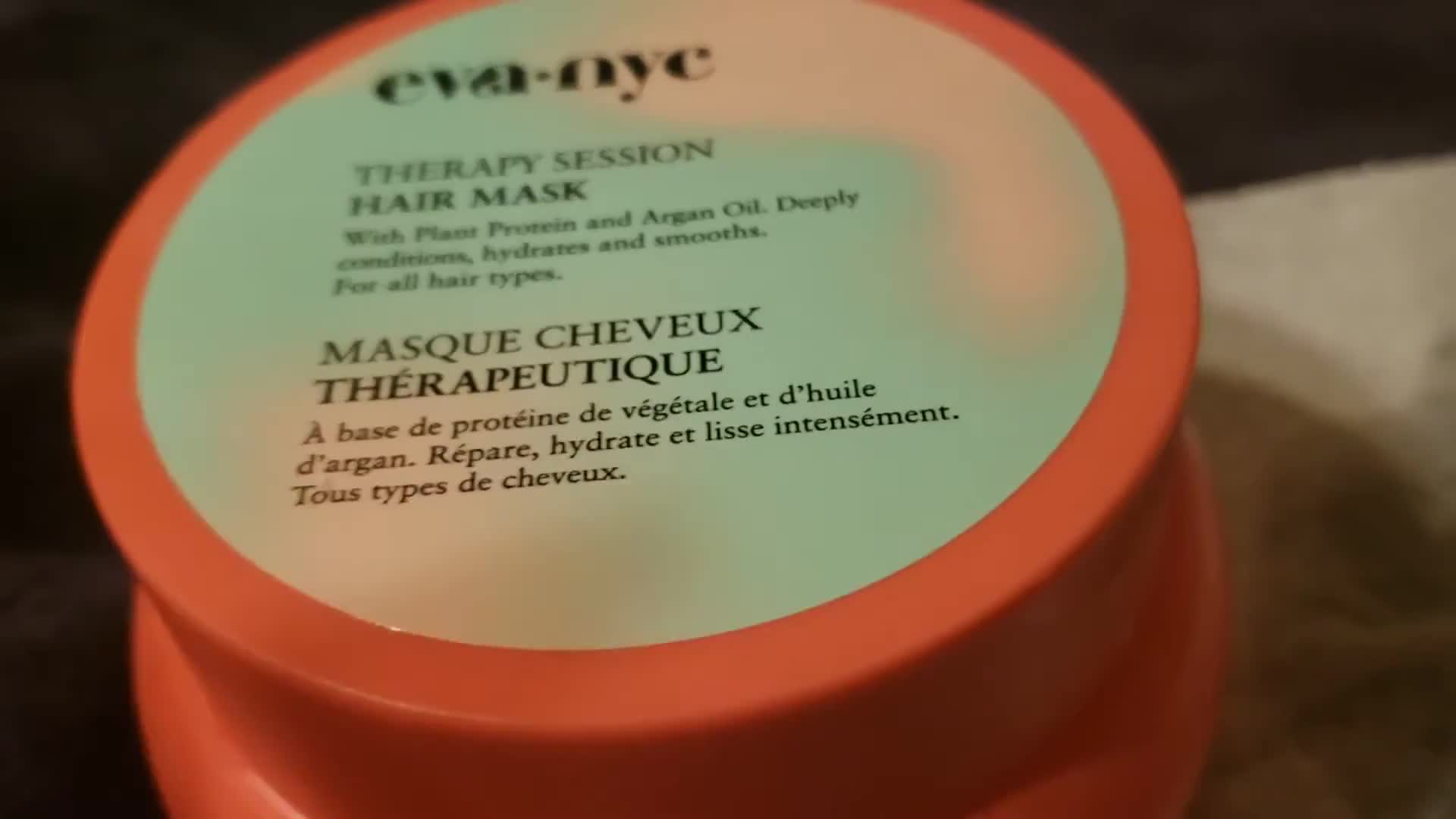 The reviewer holding the Eva NYC Therapy Session Hair Mask.