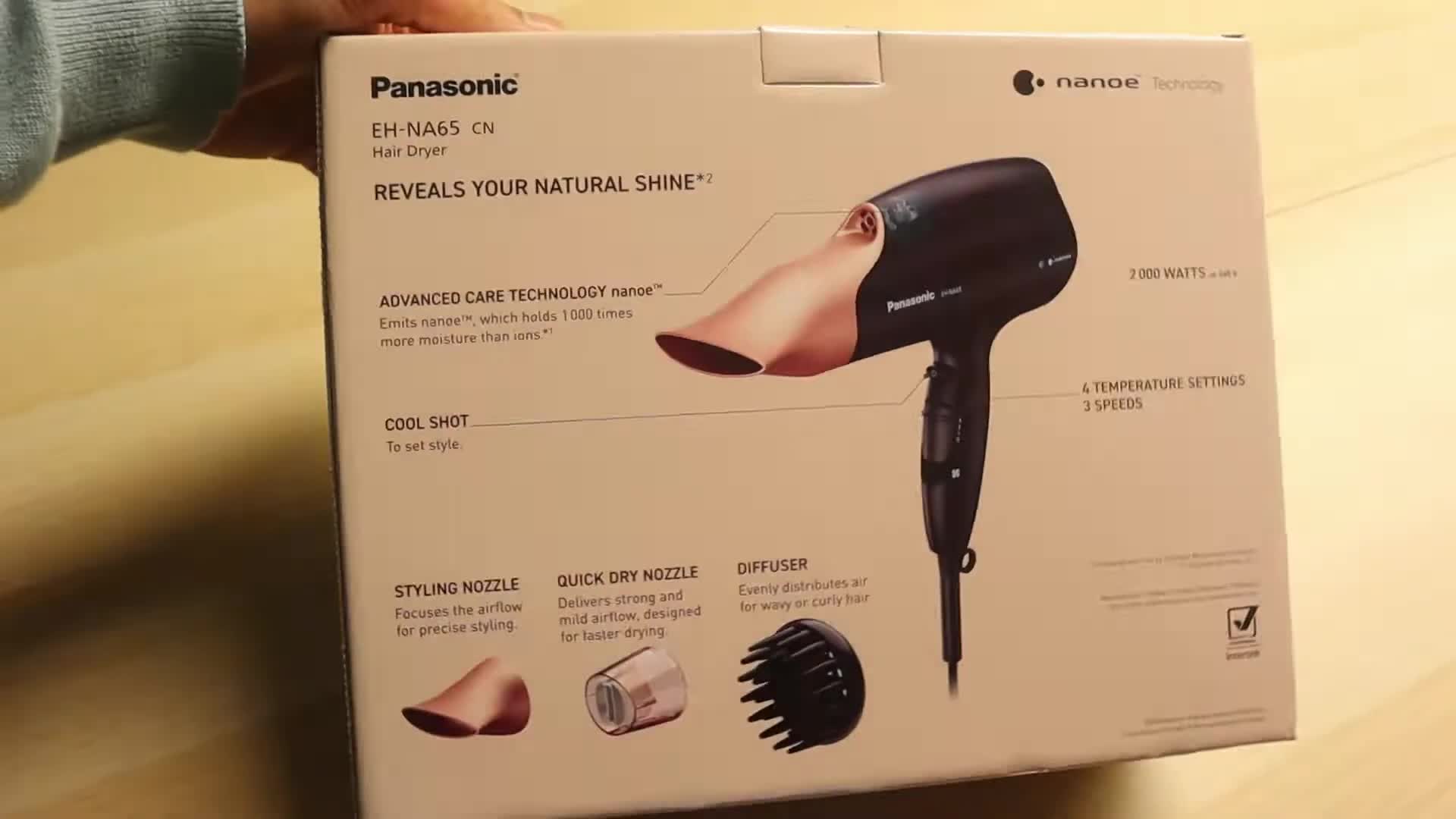 Opening the box to reveal the rose gold hair dryer.