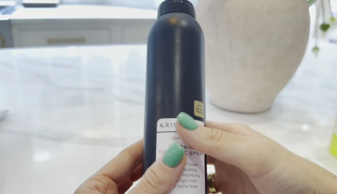 The reviewer styling her hair before using the spray.