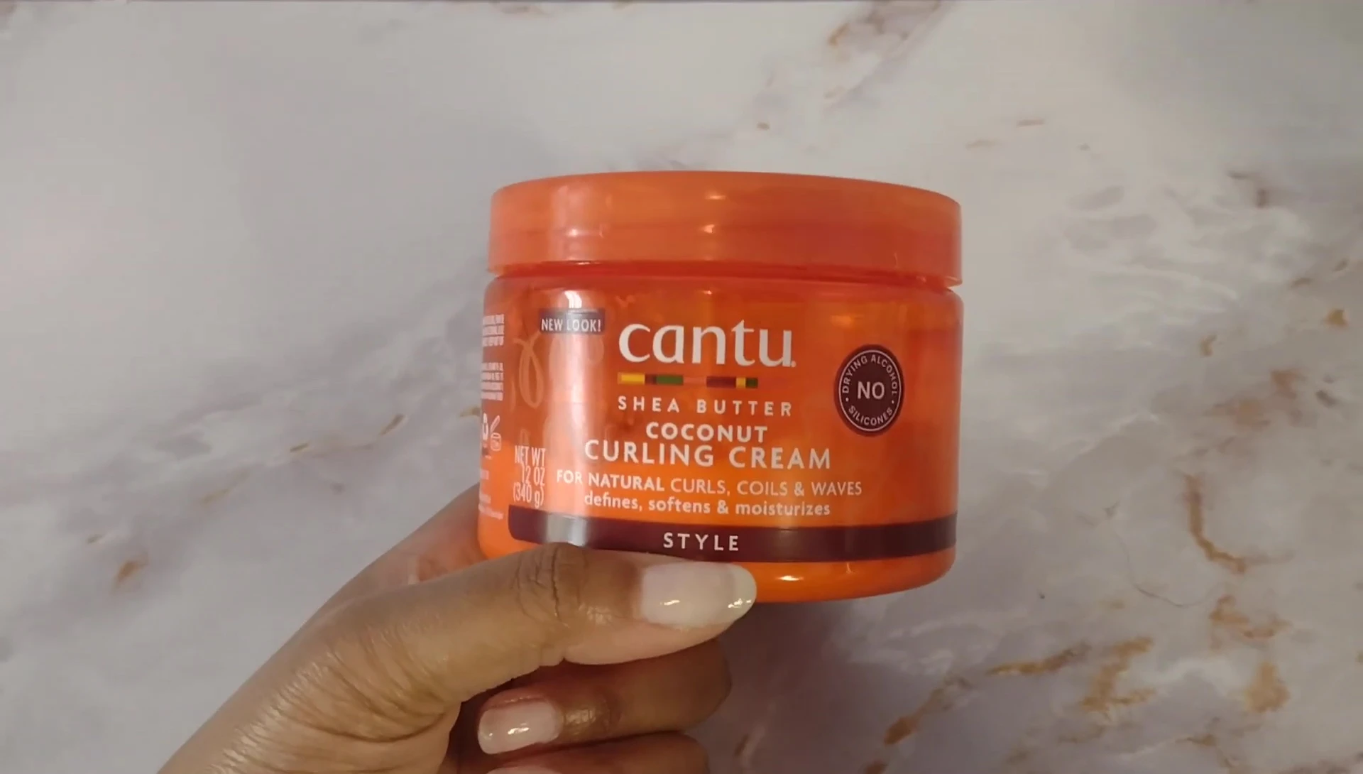 The reviewer showing the almost-empty container of the product.