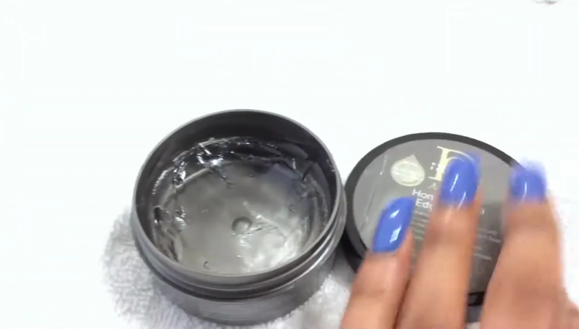 The reviewer demonstrating how to apply a small amount of product to a fingertip.