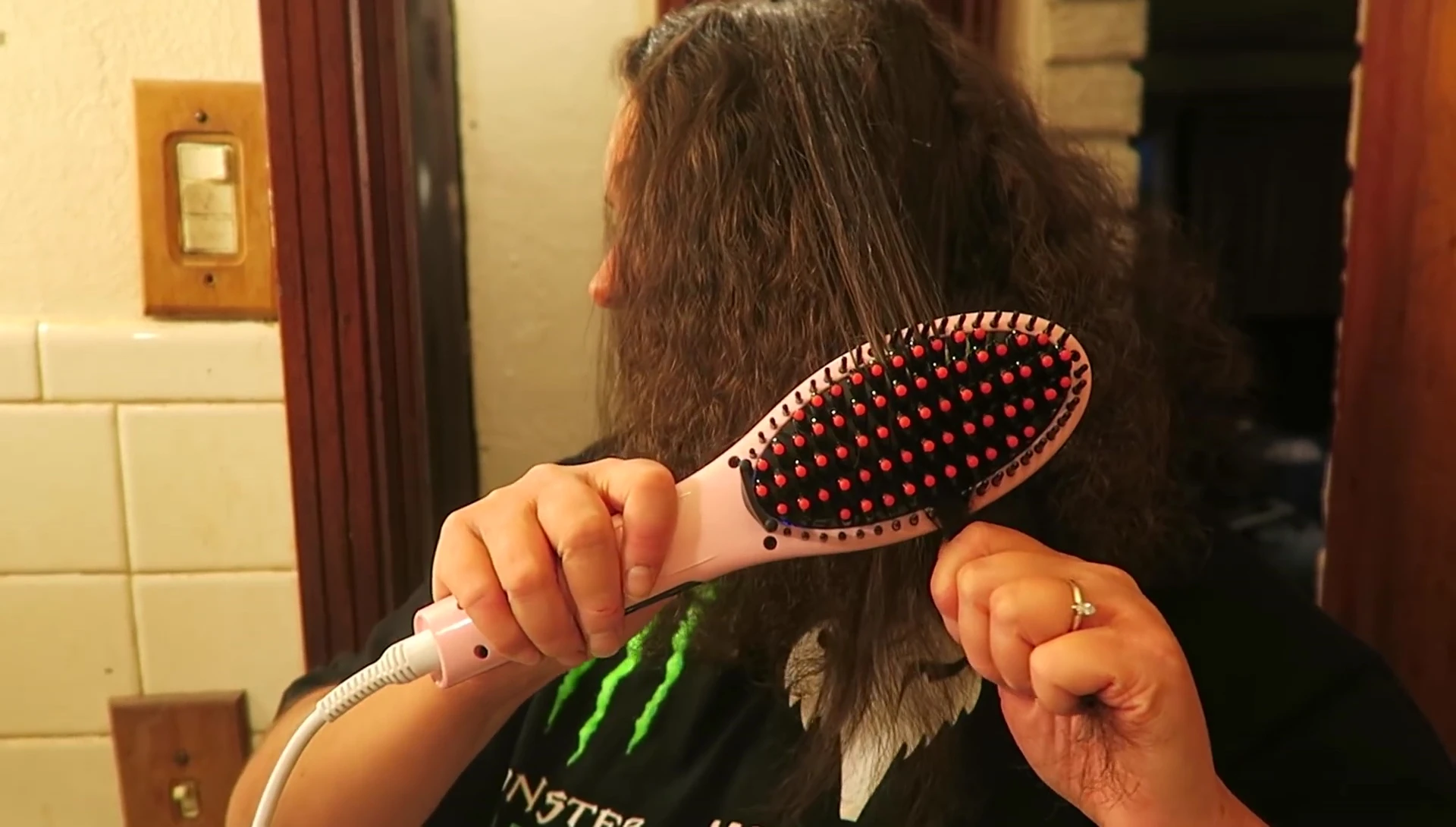 The reviewer demonstrating the rougher action of the Walmart brush on her hair.